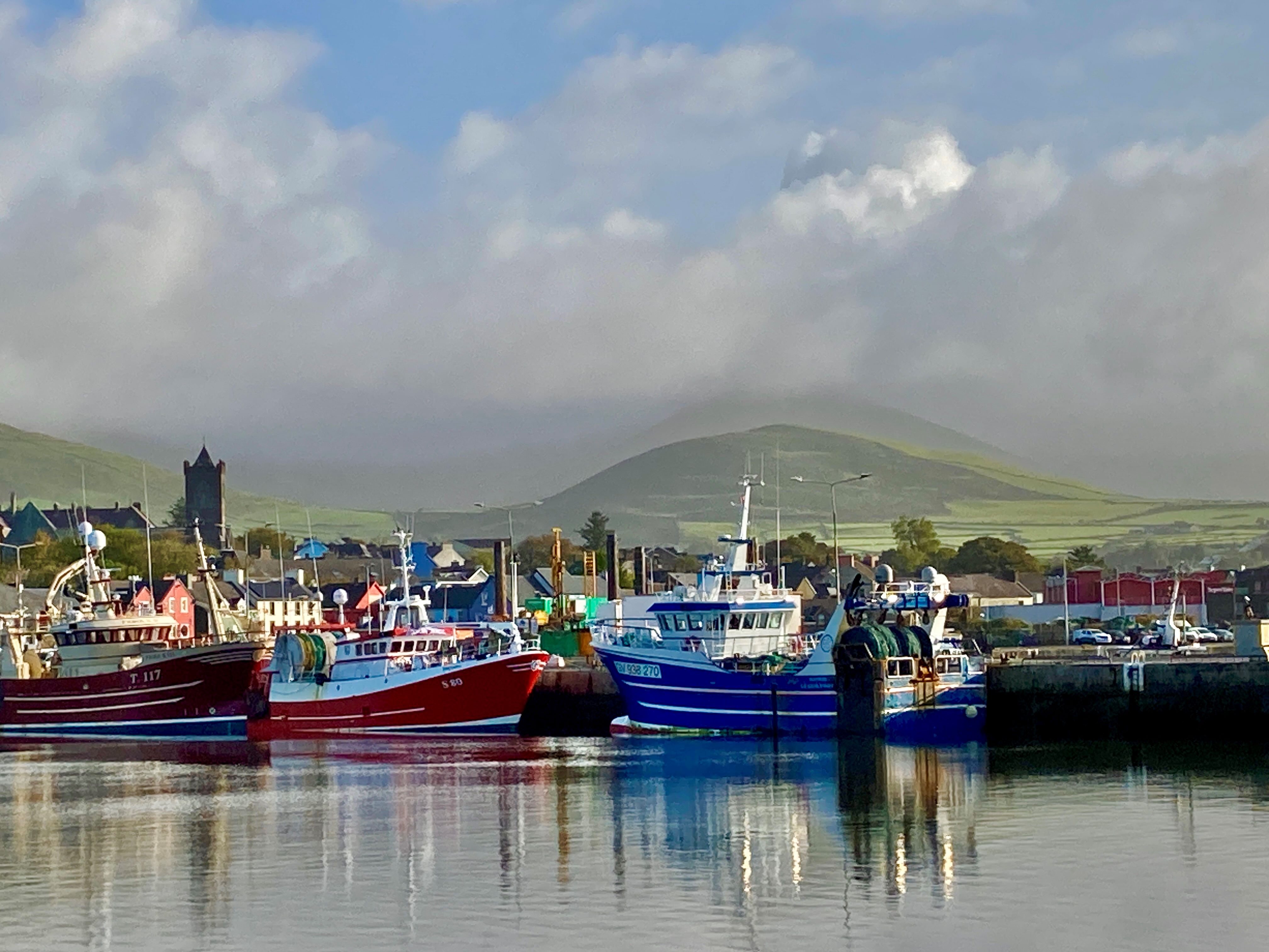 Colorful boats with grassy hills 